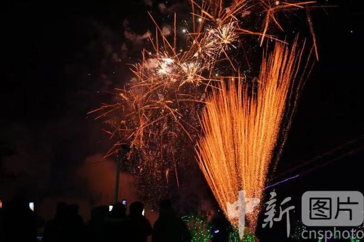 2023年12月31日晚，甘肃省兰州市榆中县栖云小镇内，市民、游客看烟花秀迎接2024新年到来。图为烟花秀表演。 中新社记者 李亚龙 摄