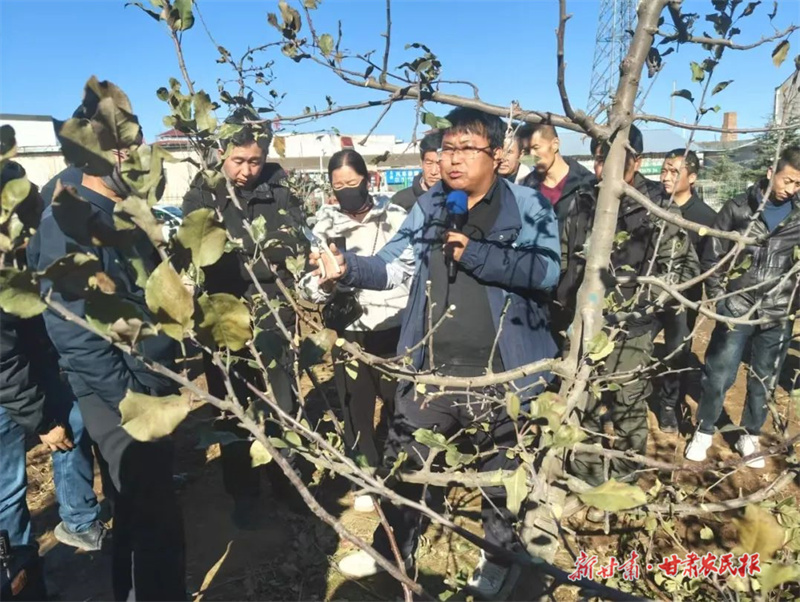 技术人员为果农讲解技术要领 孙晓娜摄
